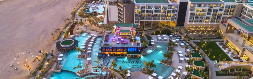 Aerial evening view of a Hard Rock all-inclusive resort with lit pools and beach access
