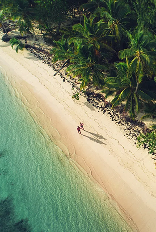 Couple walking hand in hand on a tropical beach